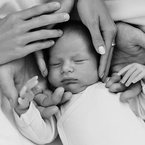 Hands holding little baby's head